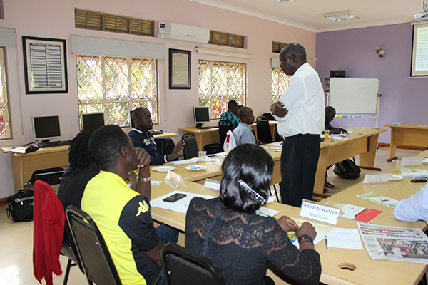 Prof. Otim-Nape listens to a journalist during the media workshop at the ACME in Bunga